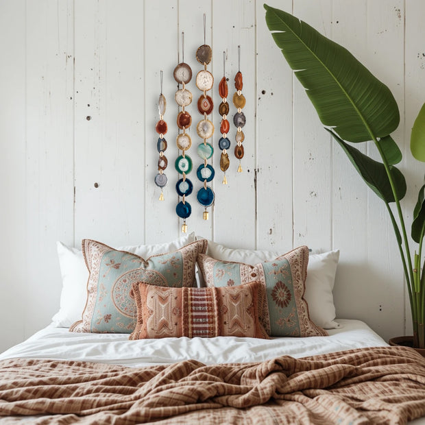Decorative pillows on a bed with a wall hanging and plant in the background