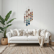 White sofa with decorative pillows and a plant in a room with a wall hanging.