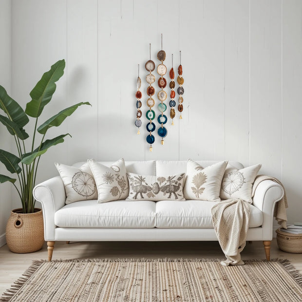 White sofa with decorative pillows and a plant in a room with a wall hanging.
