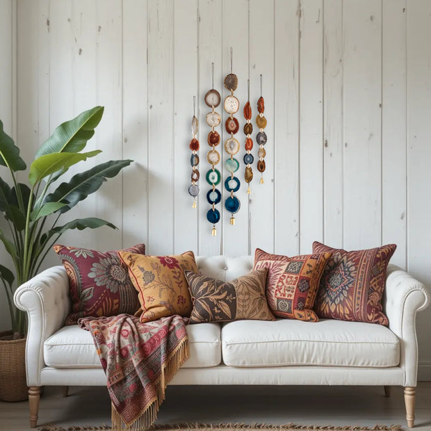 White sofa with patterned cushions and a colorful blanket in a room with wooden walls and decorative elements.