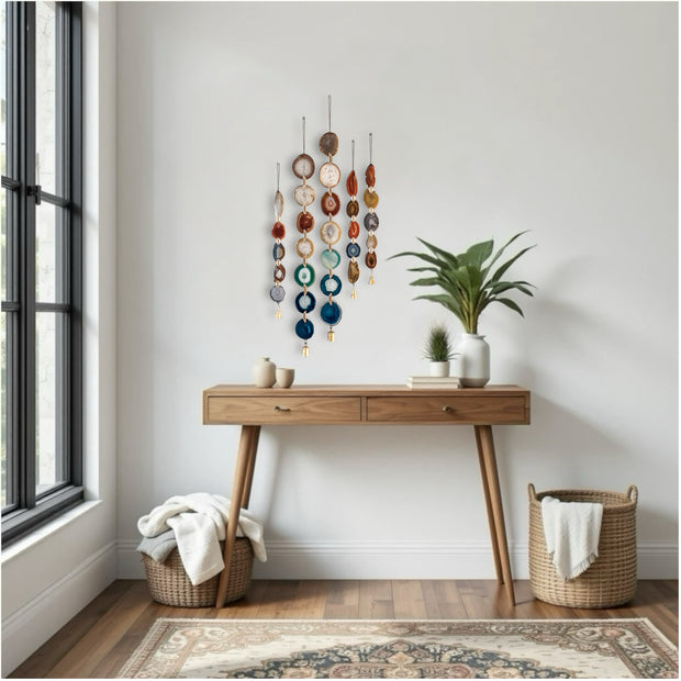 Wooden console table with agate wall hangings in a room with a window and rug.