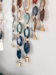 Decorative wall hanging with blue and gold bells on a white background