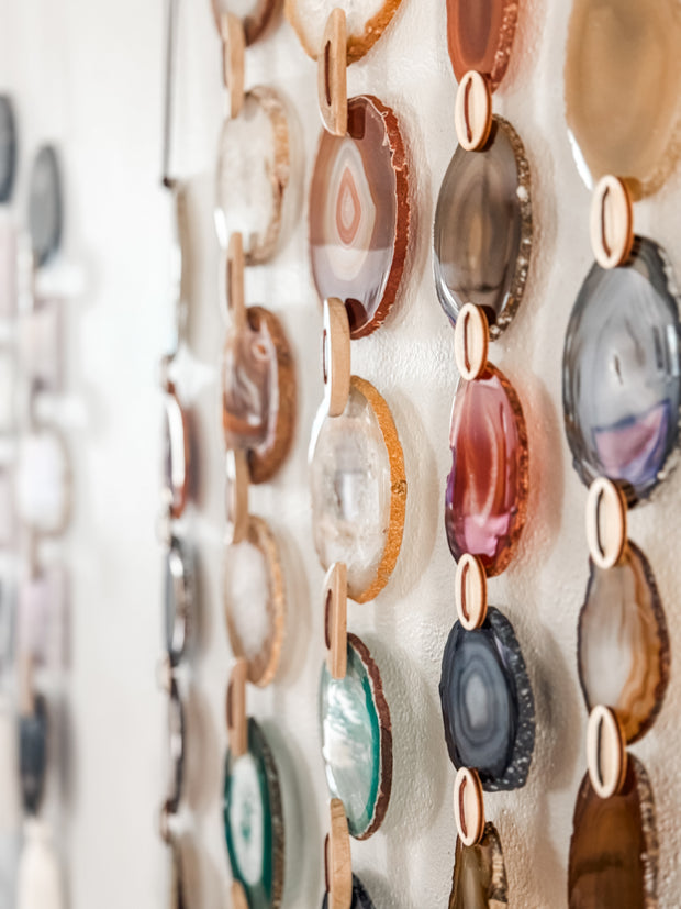 Decorative wall art with multicolored circular stones on a white background
