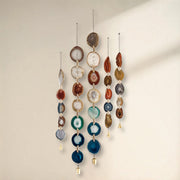 Decorative hanging mobile with multicolored stones on a plain background