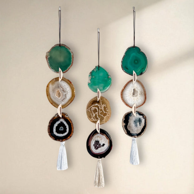 Set of hanging decorations with agate slices and tassels on a neutral background